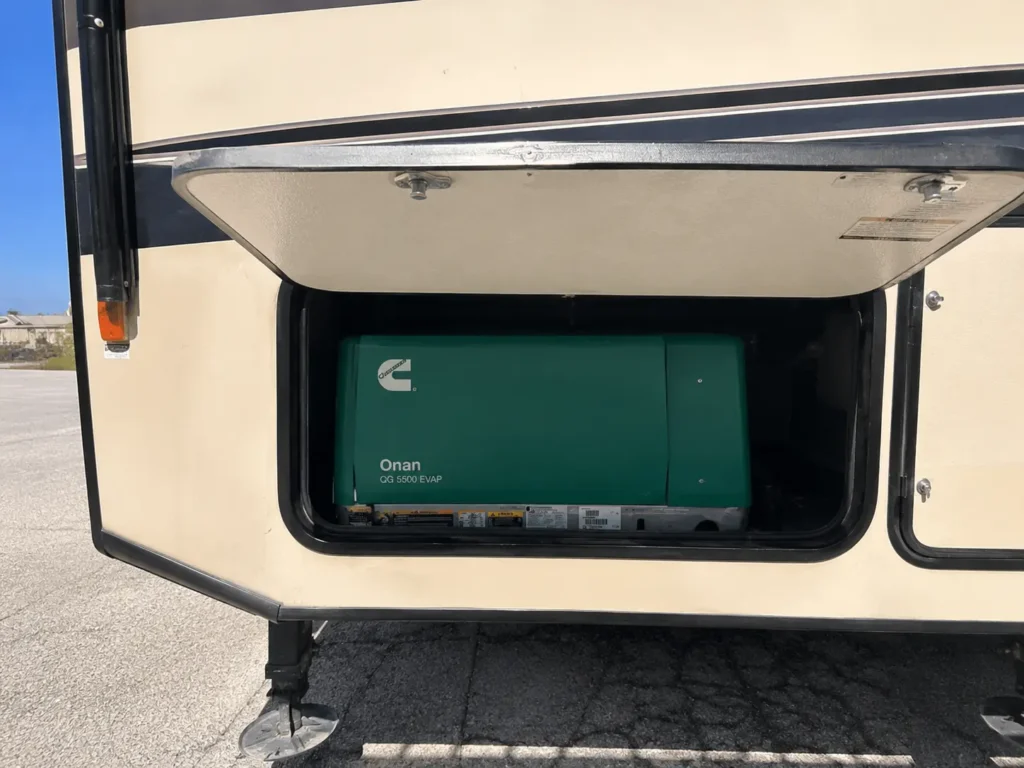 Bare hand inspecting Onan generator exterior access panel on Class A motorhome with Sandia Mountains mobile RV generator repair Albuquerque NM